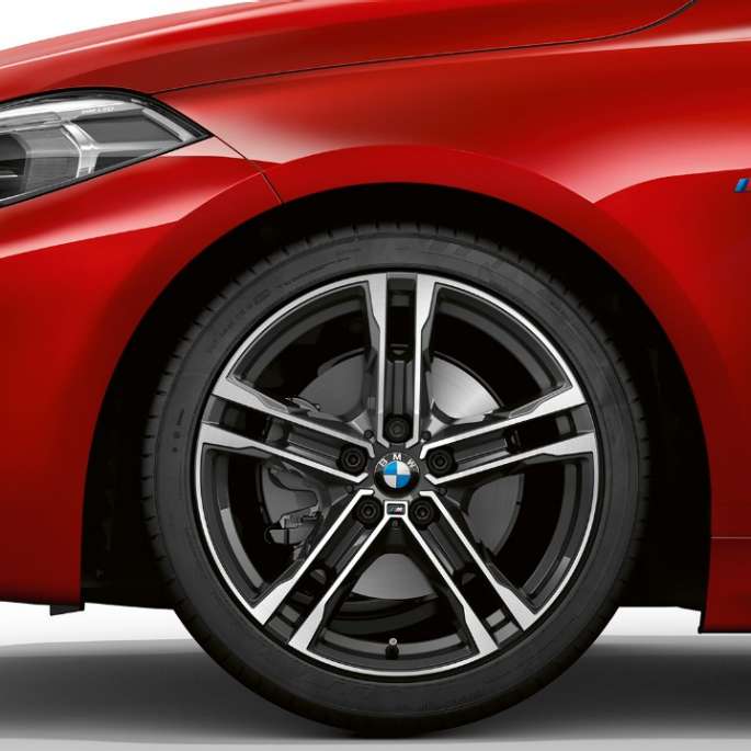 Perspectivă din lateral cu partea frontală a BMW Seria 1 Model M Sport. Perspectivă din lateral cu partea frontală a BMW Seria 1 Model M Sport în Roşu Melbourne metalizat, cu jante M din aliaj uşor de 17” Double-spoke, tip 550 M, bicolore.