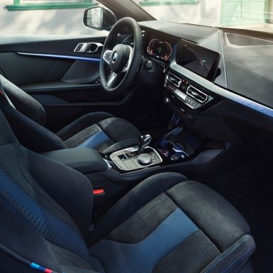 Imagine cu interiorul sportiv al BMW Seria 1. Imagine cu habitaclul BMW Seria 1 cu scaune M Sport, volan M îmbrăcat în piele şi ornamente interioare iluminate.