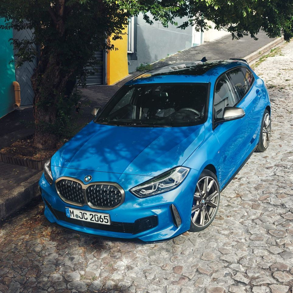 Imagine cu BMW Seria 1 pe marginea şoselei. Imagine de sus cu trei sferturi din partea frontală a BMW Seria 1 în Albastru Misano metalizat, parcând pe marginea şoselei.