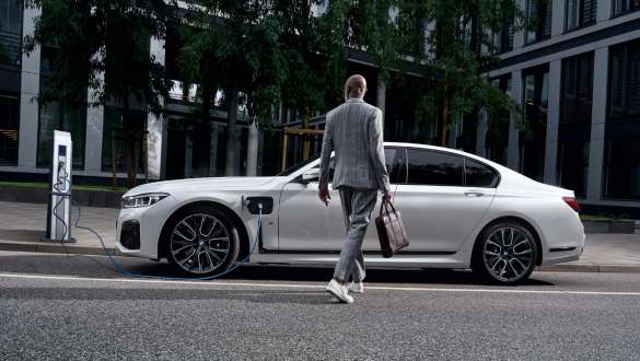 Imagine din partea laterală a unui BMW Seria 7 Sedan plug-in hybrid G11 G12 care se încarcă Imagine din partea laterală a unui BMW Seria 7 Sedan plug-in hybrid G11 G12 care se încarcă, alături de un model