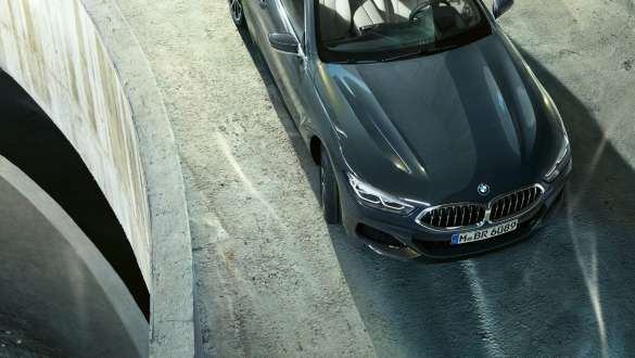 Perspectivă frontală de sus asupra BMW M850i xDrive în Gri Dravit metalizat, rulând, cu direcţie integrală adaptivă. Perspectivă frontală de sus asupra BMW M850i xDrive în Gri Dravit metalizat, rulând, cu direcţie integrală adaptivă.