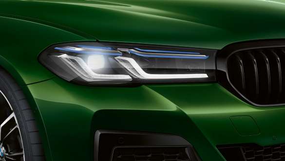 BMW M550i xDrive cu BMW Laserlight Imagine în prim plan cu partea frontală a BMW M550i xDrive Sedan, în Verde Ermes metalizat de la BMW Individual, cu faruri BMW Laserlight