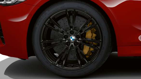 BMW M5 Competition cu frâne M Carbon cu discuri din ceramică Imagine în prim plan cu roata de la BMW M5 Competition şi frâne M Carbon cu discuri din ceramică, în Roşu Imola de la BMW Individual