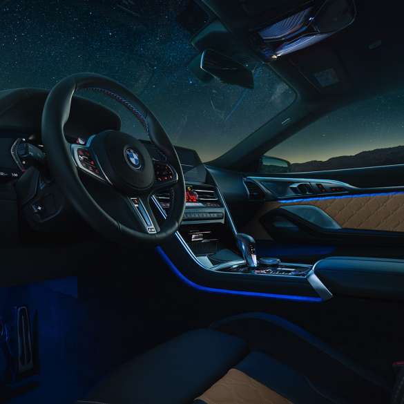 Habitaclu BMW M8 Competition Coupé. Imagine cu habitaclul BMW M8 Competition Coupé, pe timp de noapte, cu volan M îmbrăcat în piele şi lumină ambientală albastră.