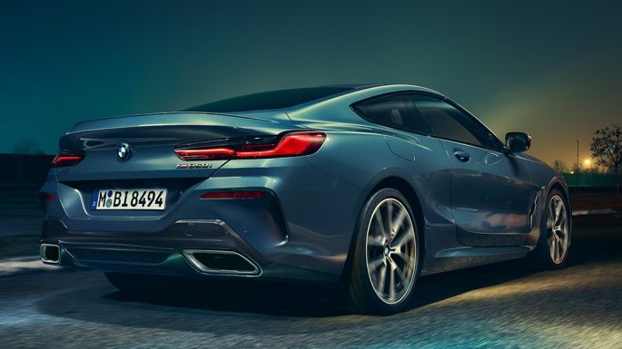 Imagine cu partea spate a BMW M850i xDrive Coupé. Imagine cu partea spate a BMW M850i xDrive Coupé în Albastru Barcelona metalizat, rulând pe timp de noapte.