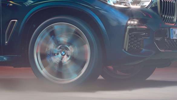 BMW X5 M50i şi M50d cu suspensie M adaptivă Imagine în prim-plan cu roata BMW X5 M50i şi M50d, F95, în Negru Carbon metalizat cu suspensie M adaptivă