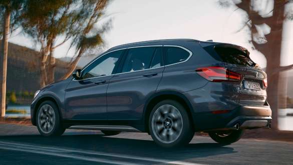 Imagine cu trei sferturi din partea spate a BMW X1. Imagine cu trei sferturi din partea spate a BMW X1, rulând într-un peisaj montan.