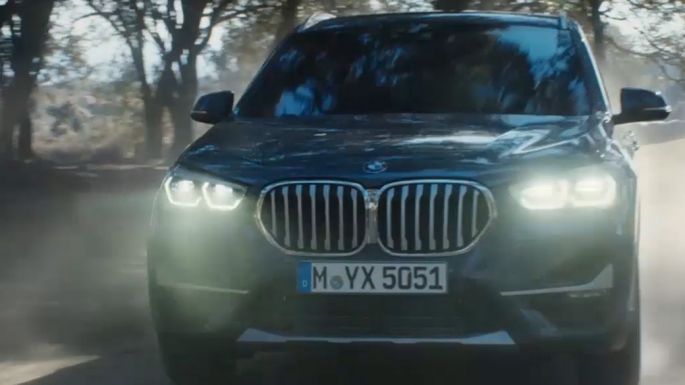 Imagine cu trei sferturi din partea frontală a BMW X1. Imagine cu trei sferturi din partea frontală a BMW X1 rulând în natură.