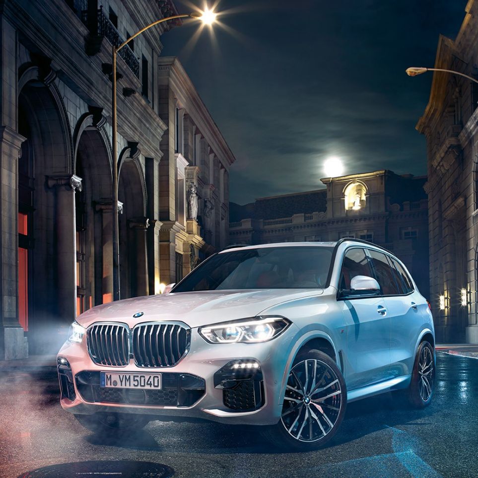 Imagine cu trei sferturi din partea frontală a BMW X5 Imagine cu trei sferturi din partea frontală a BMW X5, G05, 2018, în Alb Mineral metalizat, staţionând pe timp de noapte