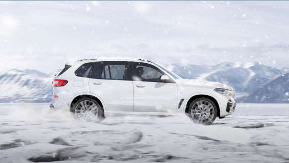 Modul de condus „xSnow” al BMW X5 Imagine din lateral cu BMW X5, G05, 2018, în Alb Mineral metalizat, rulând pe teren înzăpezit, mod de condus „xSnow”
