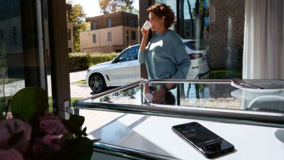 „Remote Software Upgrade” al BMW X5 Imagine cu o femeie bând o ceaşcă de cafea în timp ce actualizează software-ul automobilului său BMW X5 cu ajutorul funcţiei „Remote Software Upgrade”, G05, 2018