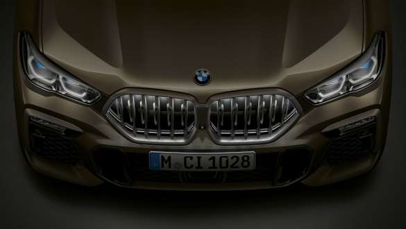 Partea frontală a BMW X6. Perspectivă de sus cu grila frontală BMW „Iconic Glow” a BMW X6 în prim-plan.