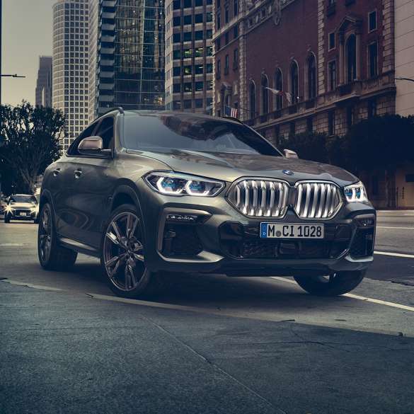 Suspensia M adaptivă „Professional” a BMW X6. Imagine cu trei sferturi din partea frontală a BMW X6, într-un mediu urban.