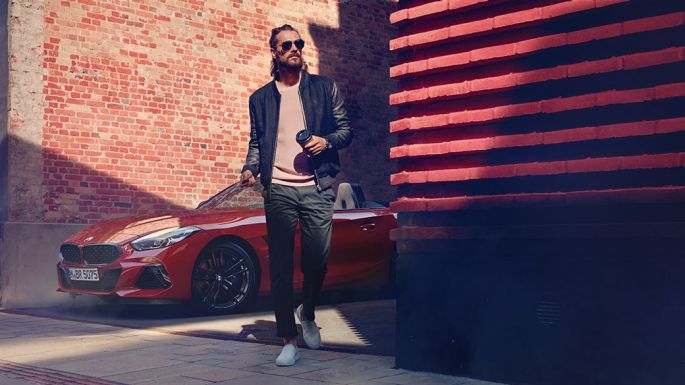BMW Z4 Roadster pe o stradă laterală Un bărbat pe o stradă laterală în faţa unui BMW Z4 Roadster
