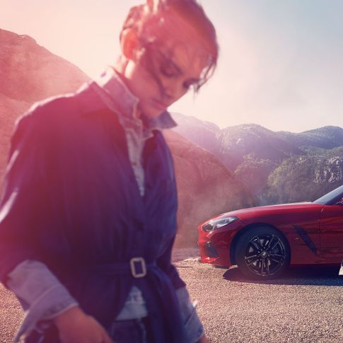 BMW Z4 Roadster în faţa unui peisaj montan Un bărbat, o femeie şi BMW Z4 Roadster în faţa unui peisaj montan