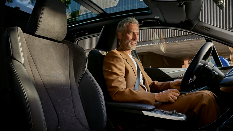 Habitaclul unui BMW Seria 2 Active Tourer cu tehnologie mild hybrid şi un bărbat la volan