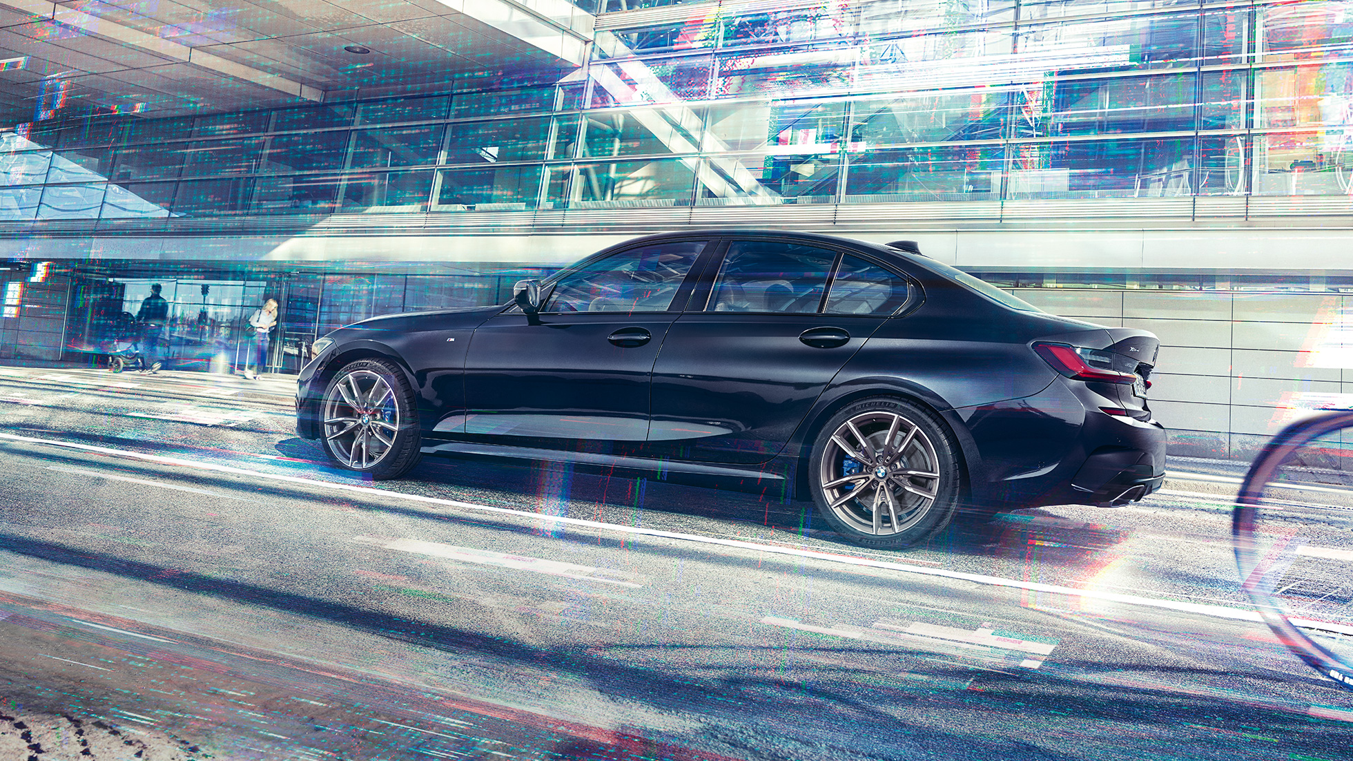 BMW M340i xDrive al BMW Seria 3 Sedan. Perspectivă laterală a BMW M340i xDrive în faţa unei clădiri dintr-o zonă urbană.