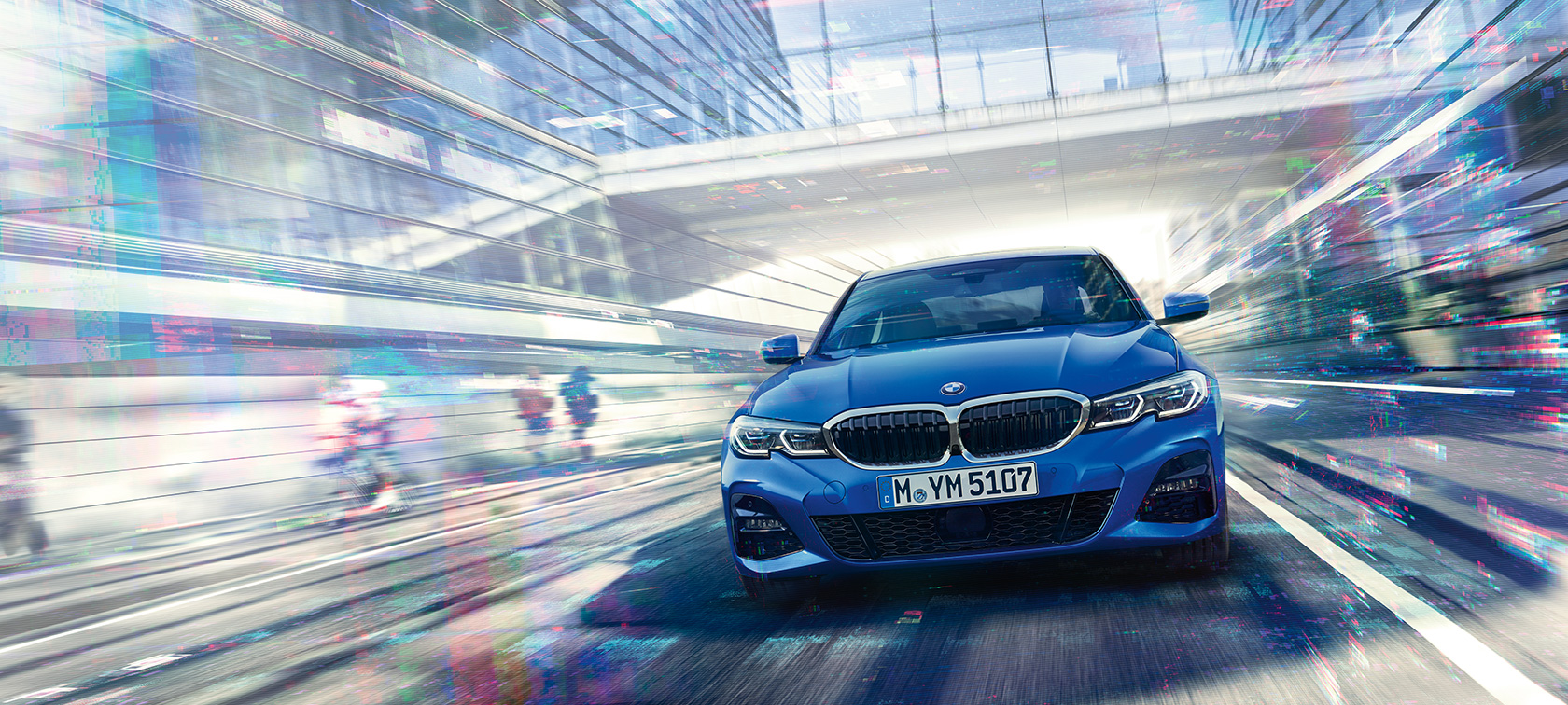 Perspectivă din faţă a BMW Seria 3 Sedan. Perspectivă din faţă a BMW Seria 3 Sedan rulând pe timp de zi, sub o clădire din sticlă.