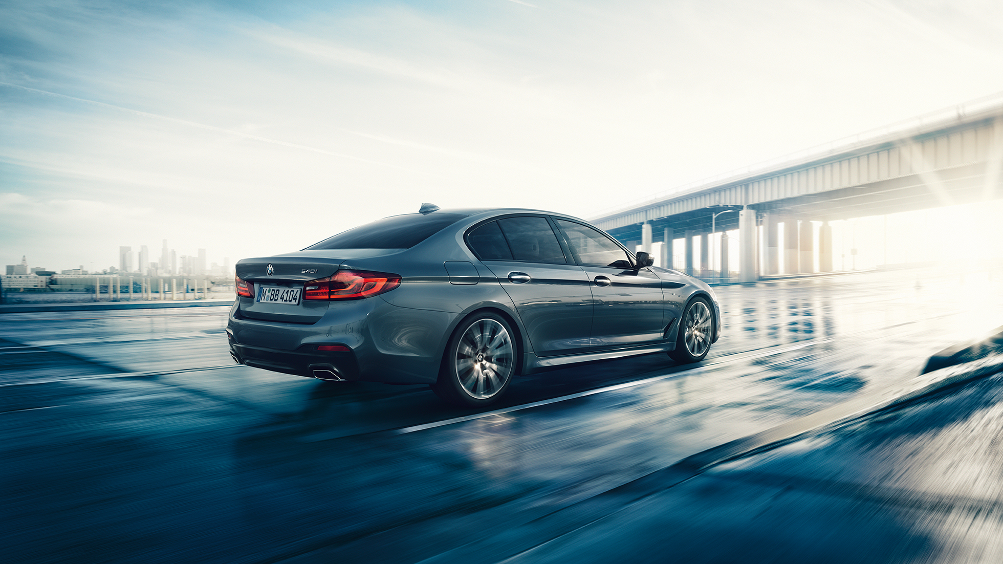 Partea spate a BMW Seria 5 Sedan Imagine cu trei sferturi din partea spate a BMW 540i Sedan, G30, în Bluestone metalizat
