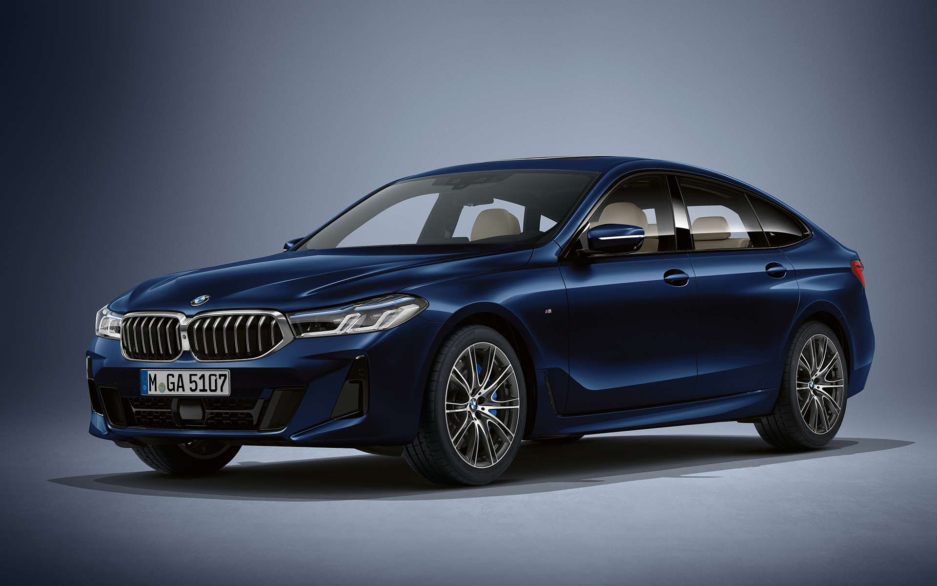 Imagine cu trei sferturi din partea frontală a BMW Seria 6 Gran Turismo, G32, 2020, în culoarea exterioară Albastru Tanzanite de la BMW Individual, staţionând