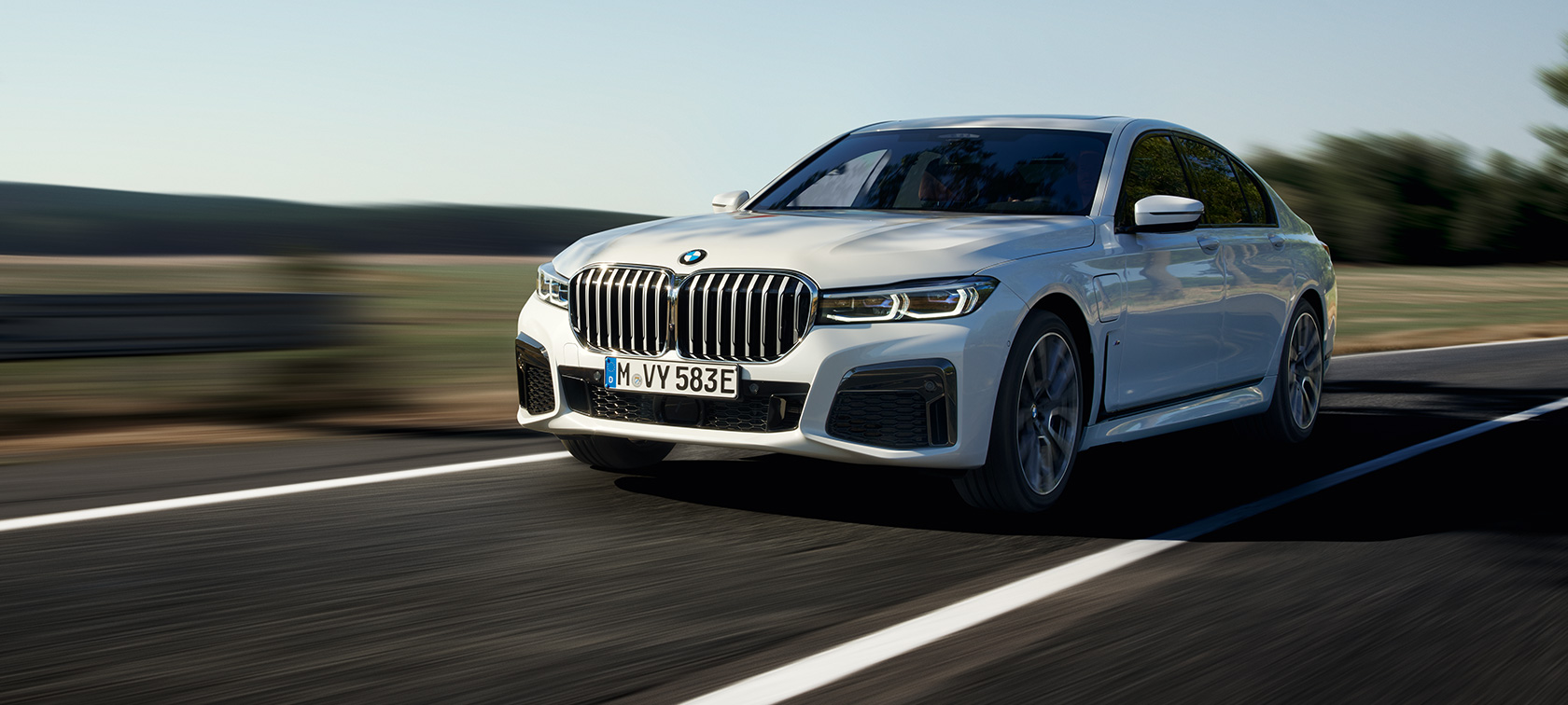 Imagine cu trei sferturi din partea frontală a unui BMW Seria 7 Sedan plug-in hybrid G11 G12 care se deplasează Imagine cu trei sferturi din partea frontală a unui BMW Seria 7 Sedan plug-in hybrid G11 G12 care se deplasează pe stradă