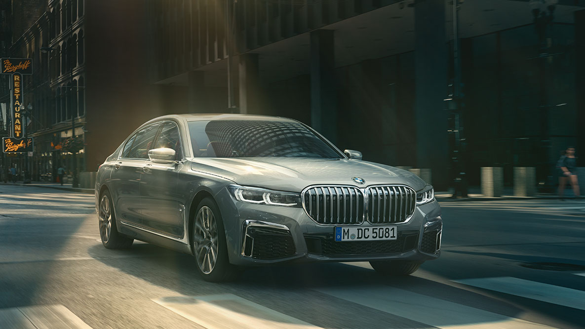 Driving Assistant Professional: imagine cu trei sferturi din partea frontală a unui BMW Seria 7 Sedan care se deplasează într-o zonă urbană BMW Seria 7 Sedan Driving Assistant Professional