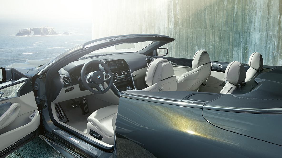 Imagine cu interiorul BMW M850i xDrive în Gri Dravit metalizat cu soft-top-ul şi portiera deschise. Imagine cu interiorul BMW M850i xDrive în Gri Dravit metalizat cu soft-top-ul şi portiera deschise.