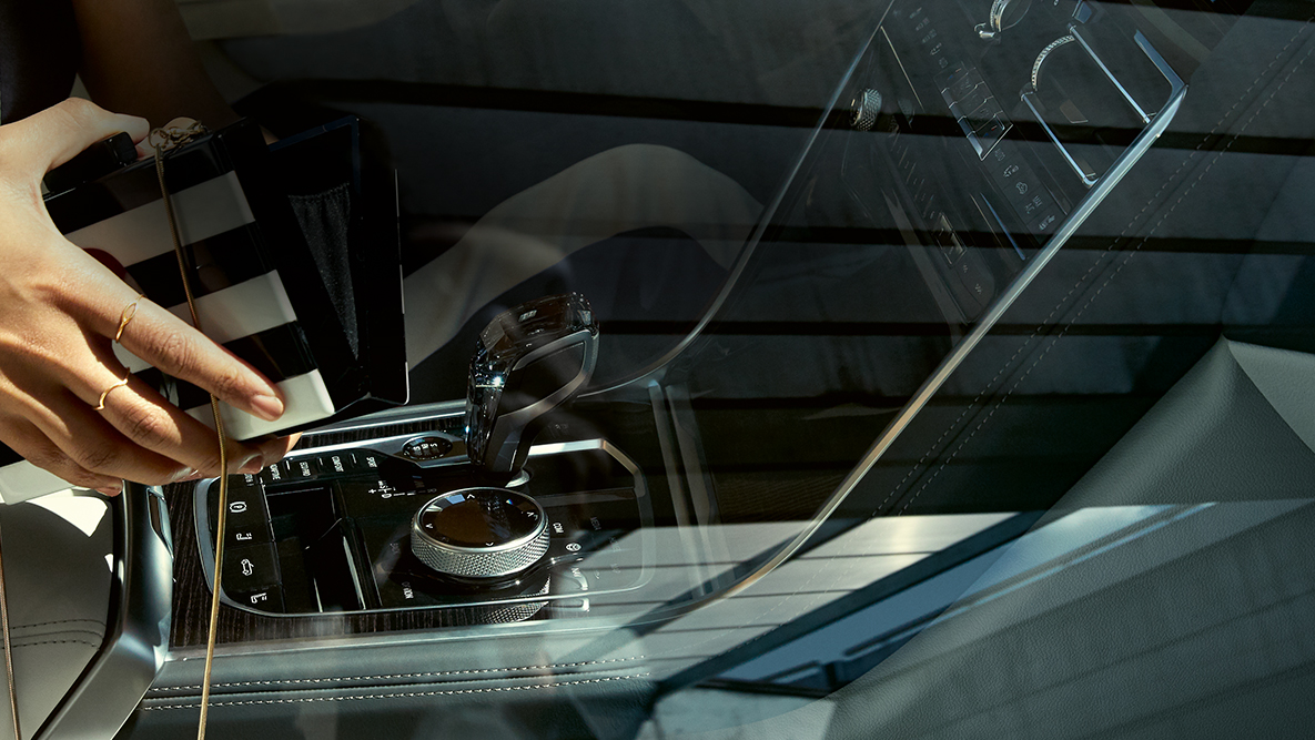 Imagine a unei femei cu geanta deschisă şi a aplicaţiilor din sticlă „CraftedClarity” din interiorul BMW M850i xDrive. Imagine a unei femei cu geanta deschisă şi a aplicaţiilor din sticlă „CraftedClarity” din interiorul BMW M850i xDrive.