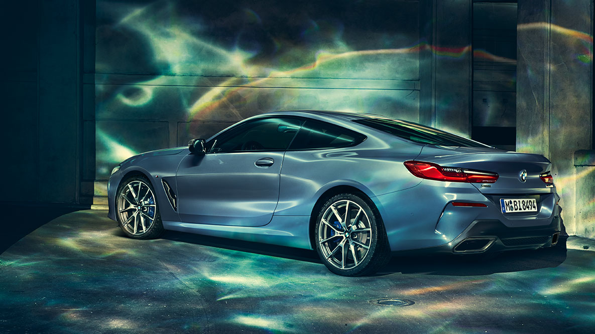 Imagine cu trei sferturi din partea spate a BMW Seria 8 Coupé. Imagine cu trei sferturi din partea spate a BMW Seria 8 Coupé pe timpul nopţii, într-un mediu urban.