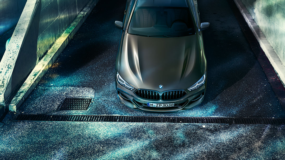 Imagine cu partea frontală a BMW Seria 8 Coupé staţionând. Imagine cu partea frontală a BMW Seria 8 Coupé cu echipamente BMW Individual staţionând noaptea, într-un peisaj urban.