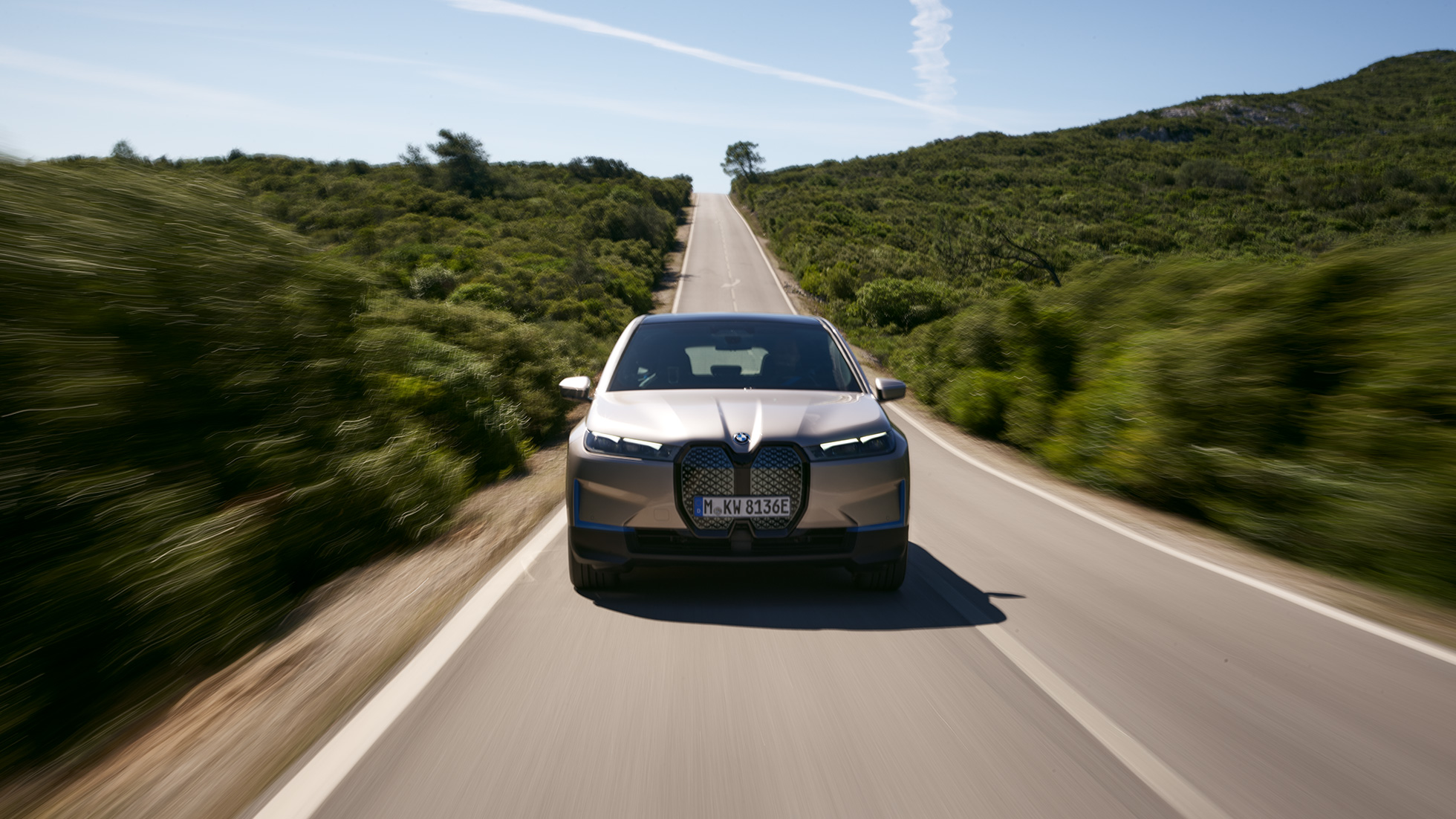 Imagine din partea frontală a BMW iX, pe şosea Imagine din partea frontală a BMW iX i20, Argintiu Cashmere, pe şosea
