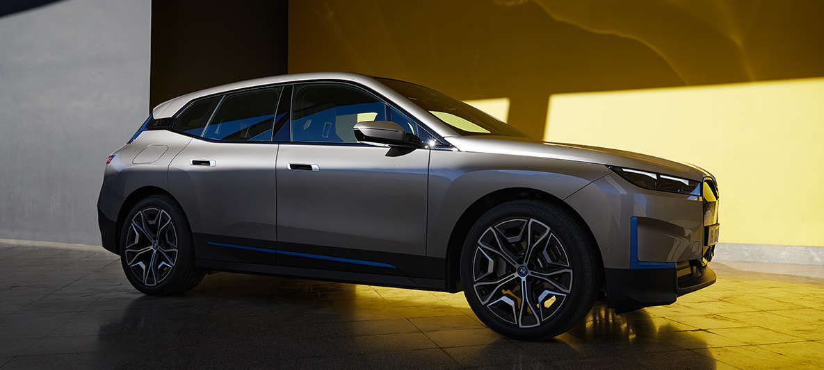 Imagine cu trei sferturi din partea laterală a BMW iX, staţionând Imagine cu trei sferturi din partea laterală a BMW iX i20, Argintiu Cashmere, staţionând