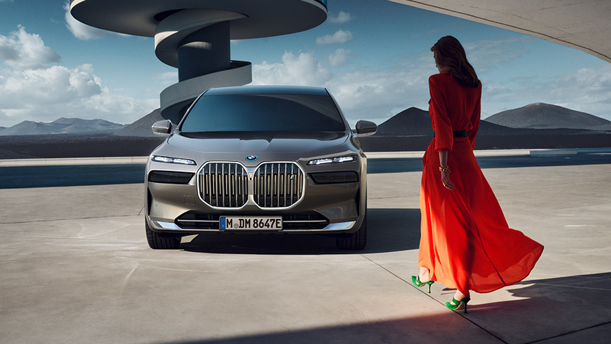 Imagine din partea frontală a unui BMW i7 Sedan cu un model într-o zonă urbană