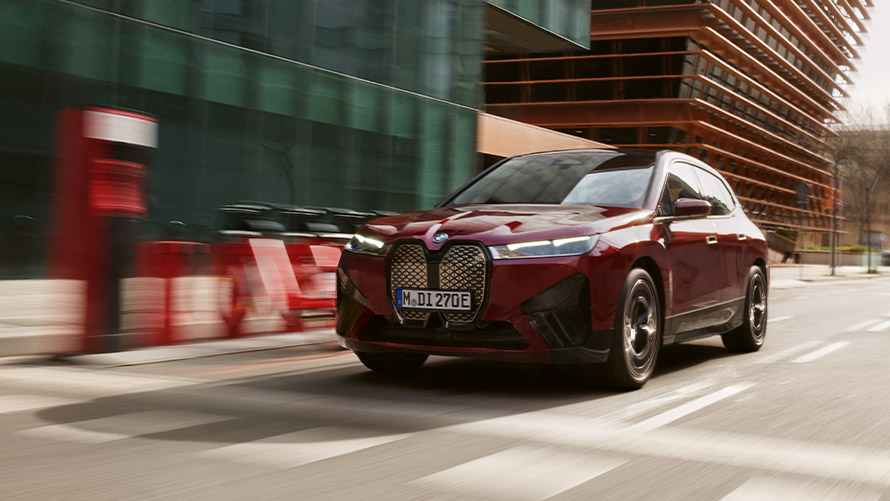 Imagine cu trei sferturi din partea frontală a unui BMW iX I20 din prima generaţie în timp ce se deplasează Imagine cu trei sferturi din partea frontală a unui BMW Seria i BMW iX I20 din prima generaţie în timp ce se deplasează