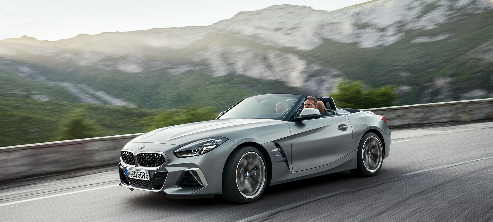 BMW Z4 M40i, G29, rulând cu un peisaj montan pe fundal Imagine cu trei sferturi din partea frontală a BMW Z4 M40i Roadster Cabriolet, G29, 2019, în Gri Frozen metalizat de la BMW Individual, rulând cu un peisaj montan pe fundal