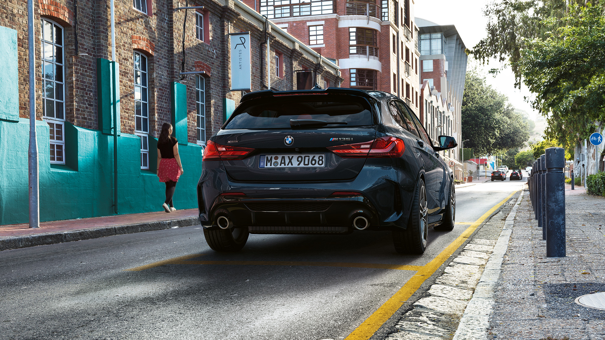 Perspectivă spate a BMW M135i xDrive. Perspectivă spate a BMW M135i xDrive în Negru Sapphire metalizat, parcând.