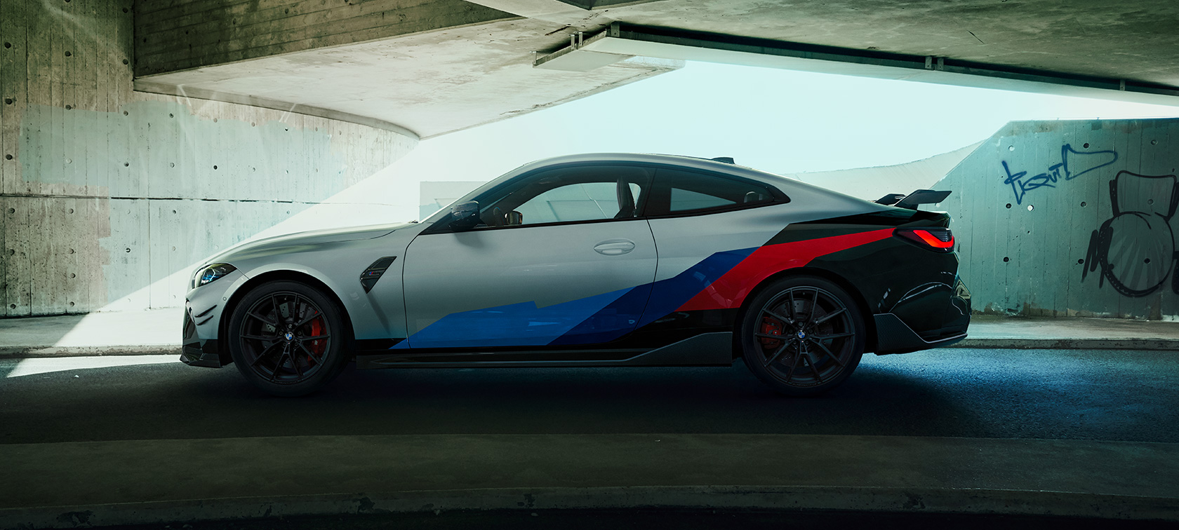 BMW M4 Coupé G82 2020, cu accesorii BMW M Performance Imagine cu partea laterală a BMW M4 Coupé G82 2020, cu accesorii BMW M Performance