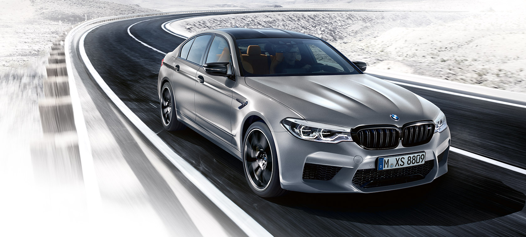 Detaliile importante de design. Imagine cu trei sferturi din partea frontală a BMW M5 Competition rulând.