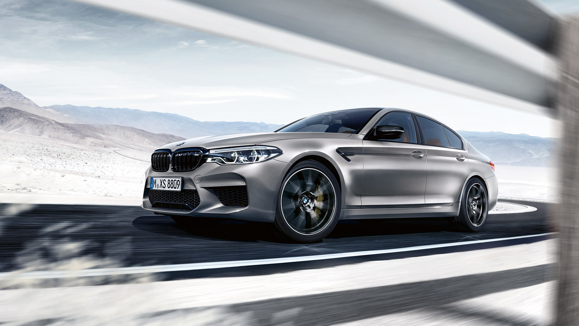 xDrive M. Imagine cu trei sferturi din partea frontală a BMW M5 Competition rulând.