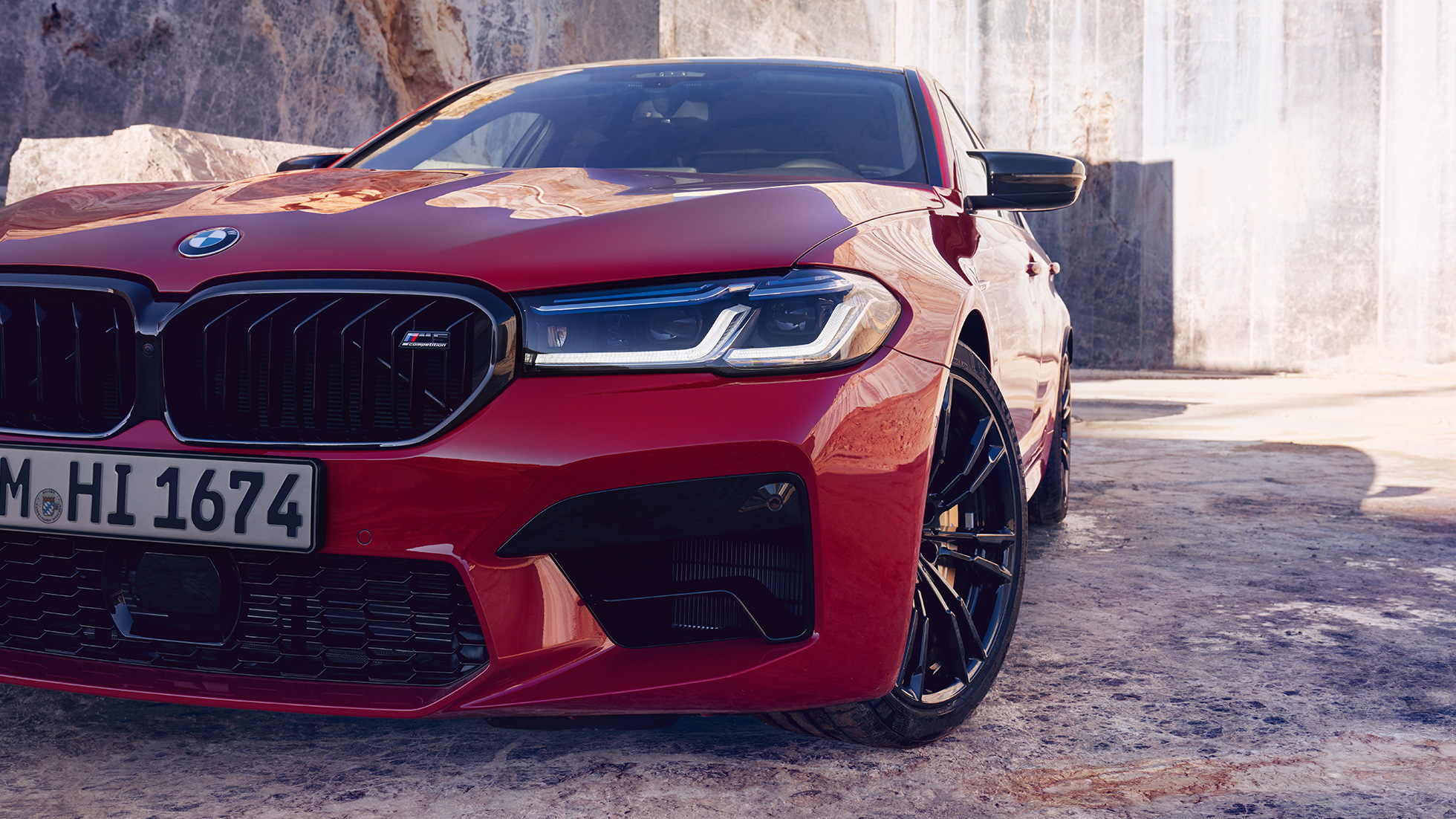 Imagine în prim plan cu partea frontală a BMW M5 Competition, F90, LCI, Facelift, 2020, cu farurile BMW Laserlight Imagine în prim plan cu partea frontală a BMW M5 Competition, F90, LCI, Facelift, 2020, în Roşu Imola de la BMW Individual, cu farurile BMW Laserlight