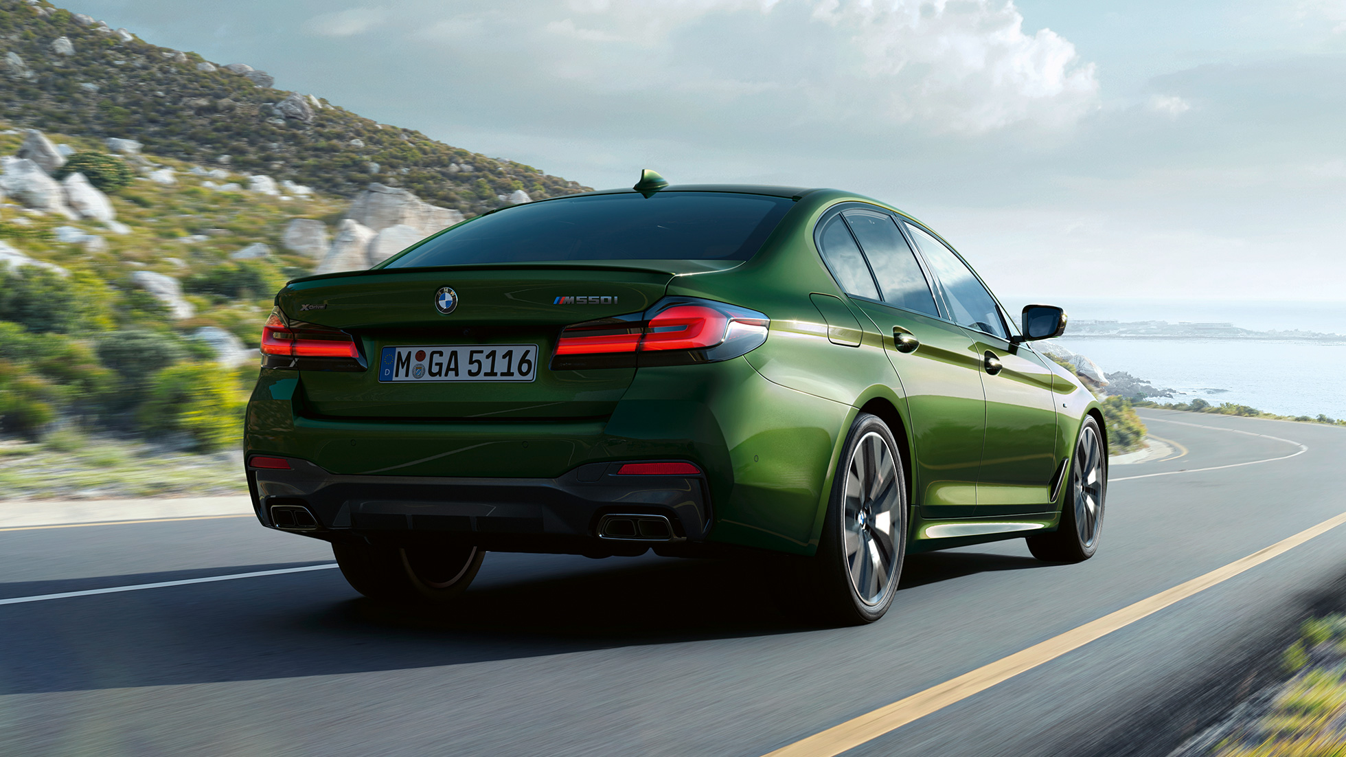 Imagine cu partea spate a BMW M550i xDrive Sedan, G30, LCI, Facelift, 2020 Imagine cu partea spate a BMW M550i xDrive Sedan, G30, LCI, Facelift, 2020, în Verde Ermes metalizat de la BMW Individual, rulând pe autostradă
