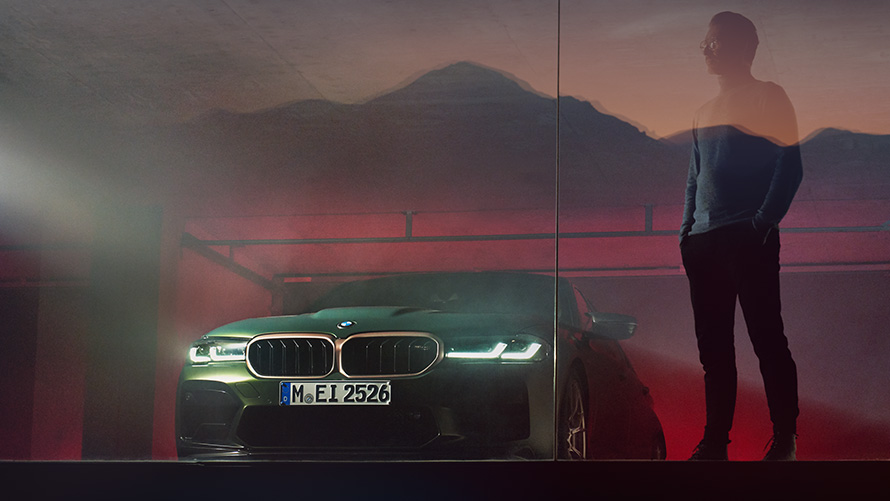Imagine din partea frontală a BMW M5 CS F90 2021 cu bărbat Imagine din partea frontală a BMW M5 CS F90 2021 în Verde Frozen Deep, cu bărbat