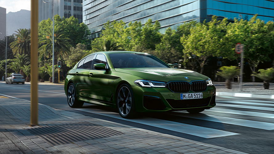 Imagine cu trei sferturi din partea frontală a BMW M550i xDrive Sedan, în Verde Ermes de la BMW Individual
