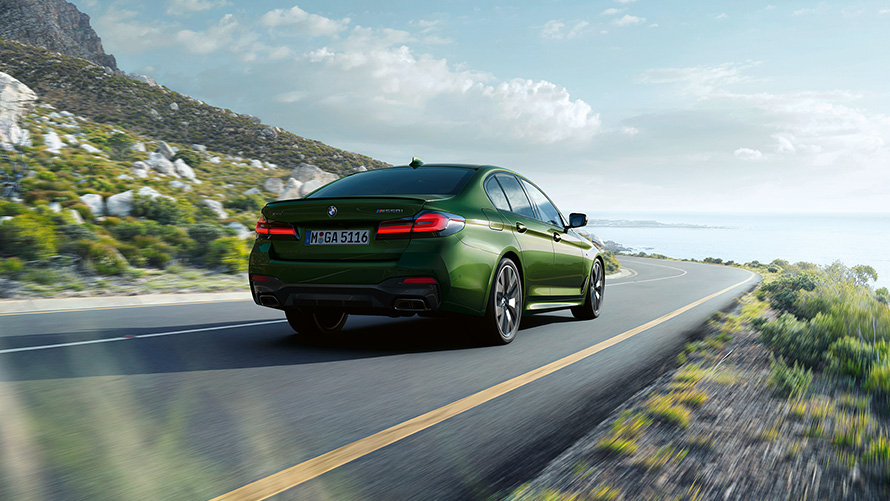 Imagine cu trei sferturi din partea spate a BMW M550i xDrive Sedan, în Verde Ermes metalizat de la BMW Individual