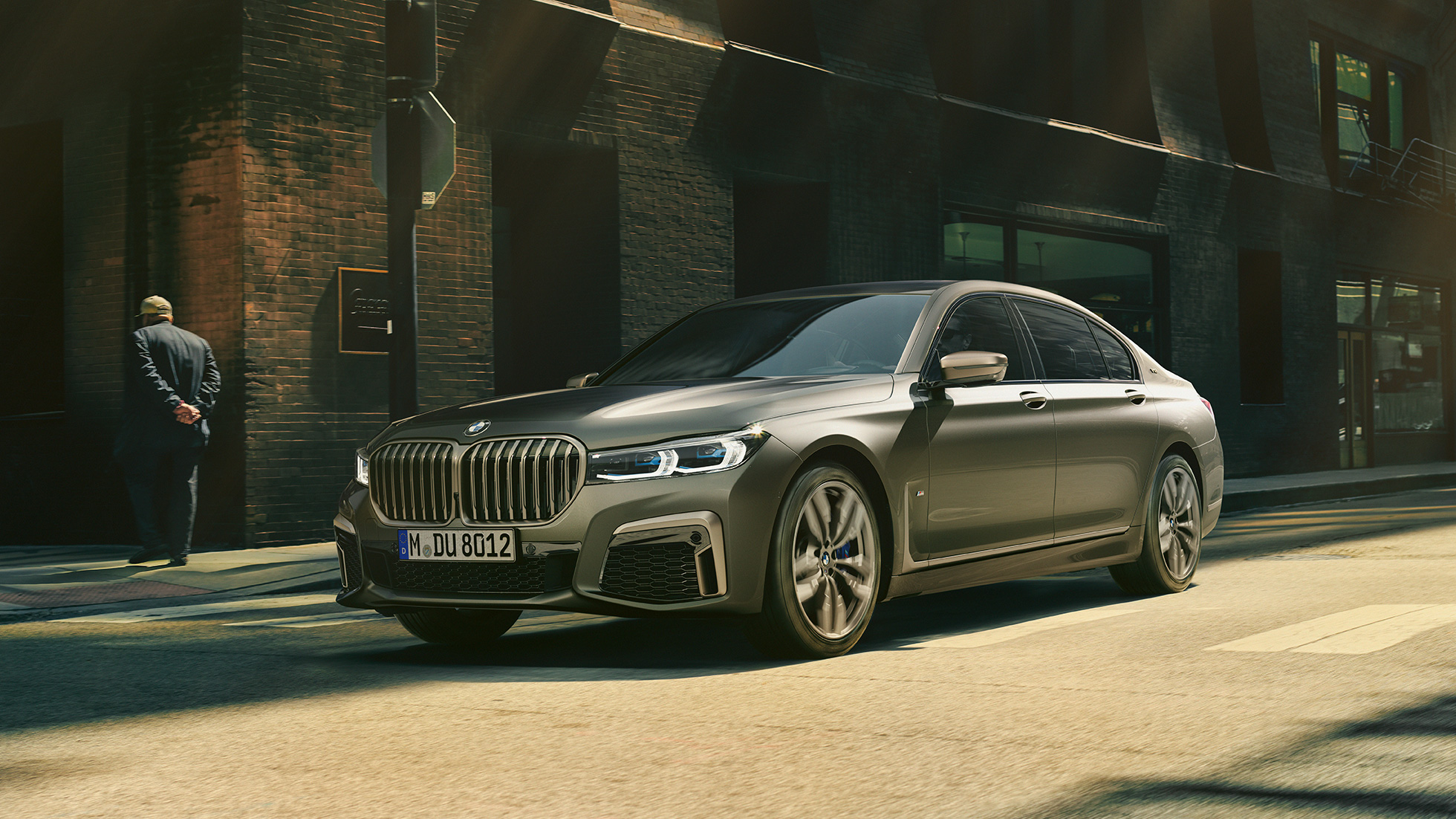 BMW M760Li xDrive Sedan într-un mediu urban Imagine din lateral cu partea frontală a BMW M760Li xDrive Sedan, rulând pe stradă într-un mediu urban