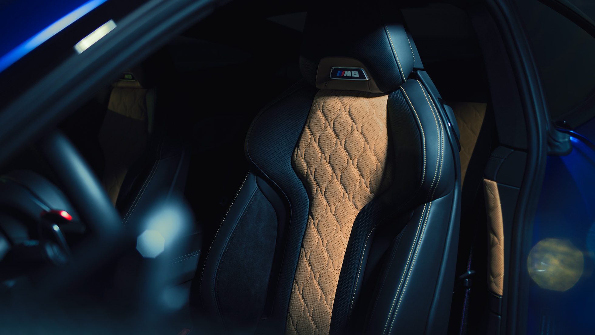 Scaunele M Sport ale BMW M8 Competition Coupé. Imagine cu scaunele M Sport cu inscripţia „M8” şi tapiţerie din piele Merino integrală neagră cu cusături contrastante în Bej Midrand, ale BMW M8 Competition Coupé.