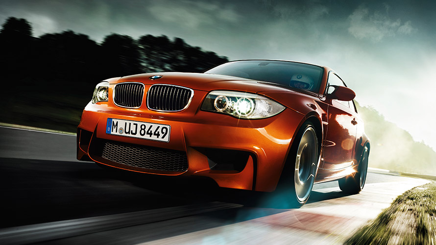 Imagine cu trei sferturi din partea frontală a BMW Seria 1 M Coupé E82, rulând pe stradă BMW M, imagine cu trei sferturi din partea frontală a BMW Seria 1 M Coupé E82, rulând pe stradă