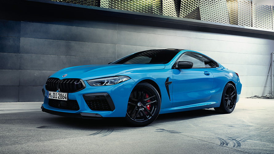 Imagine cu trei sferturi din partea din spate a BMW M8 F92, staţionând cu un model Imagine cu trei sferturi din partea din spate a BMW M BMW M8 F92, staţionând cu un model