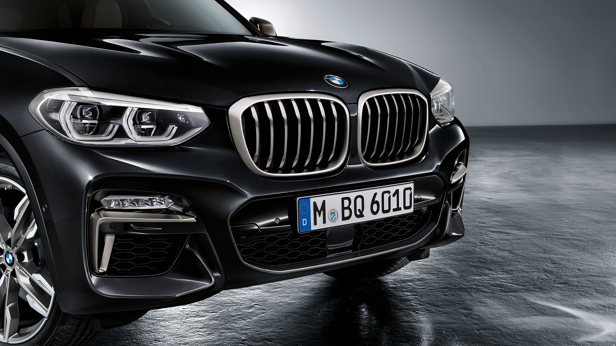 Imagine cu partea frontală a BMW X3 M40i şi BMW X3 M40d. Imagine cu partea frontală exterioară a BMW X3 M40i şi BMW X3 M40d în Negru Sapphire metalizat, cu elemente de design în Gri Cerium.