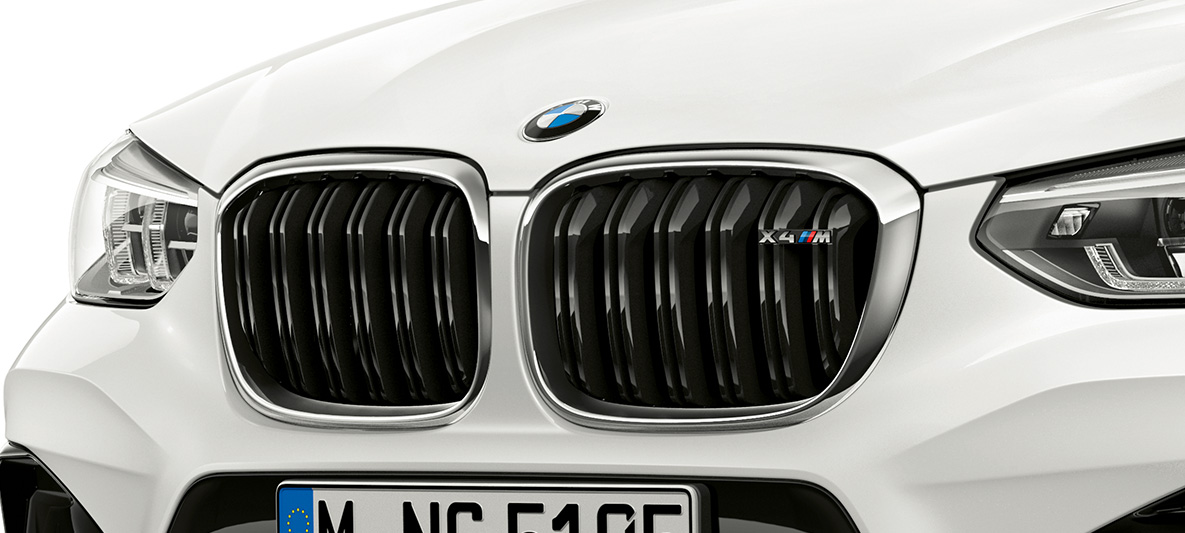 Imagine cu BMW X4 M, cu grilă M a radiatorului. Imagine cu partea frontală exterioară a BMW X4 M în Alb Alpine, cu grilă M a radiatorului cu detalii cromate şi inscripţionarea denumirii modelului.